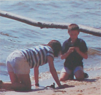 Photo of a mother and her son looking for shells on the beach